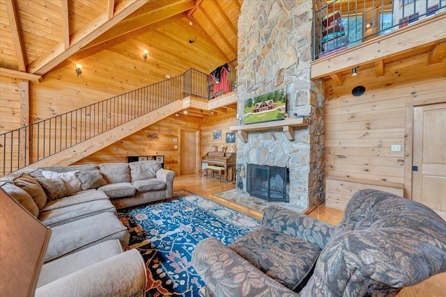 1769 Scenic View Rd, Moneta, VA 24121 - living room featuring high vaulted ceiling, wood walls, a wooden ceiling with exposed beams, stairs, and a fireplace
