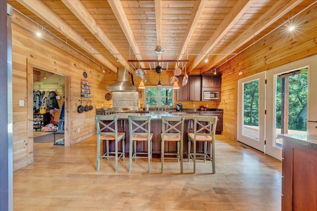 1769 Scenic View Rd, Moneta, VA 24121 - kitchen featuring stainless steel microwave, wooden walls, a wood ceiling with exposed beams, a center island, and light wood finished floors