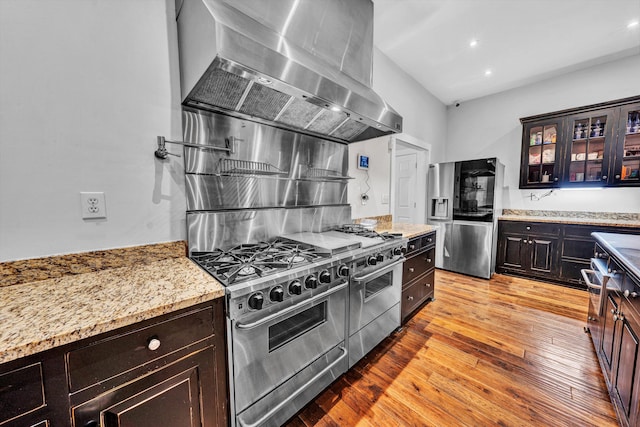 3150 Green Ridge Rd NW, Roanoke, VA 24019 - kitchen featuring wall chimney exhaust hood, stainless steel appliances, glass insert cabinets, light stone counters, and light wood finished floors