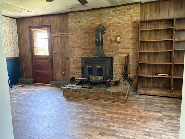 713 Rose Ave, Covington, VA 24426 - unfurnished living room with a wood stove, wood-type flooring, ceiling fan, and wooden walls