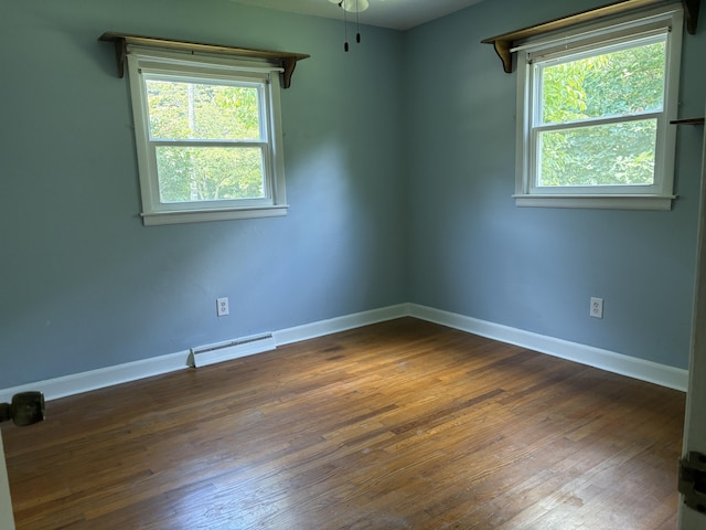 713 Rose Ave, Covington, VA 24426 - spare room featuring a baseboard radiator, dark wood-type flooring, and plenty of natural light