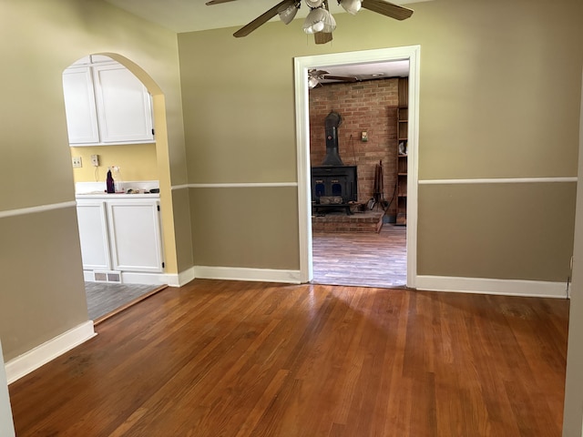 713 Rose Ave, Covington, VA 24426 - unfurnished dining area with a ceiling fan, dark wood-style floors, and a wood stove