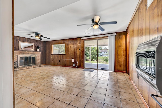 3716 Bower Rd, Roanoke, VA 24018 - unfurnished living room with a ceiling fan, wood walls, light tile patterned flooring, heating unit, and a brick fireplace
