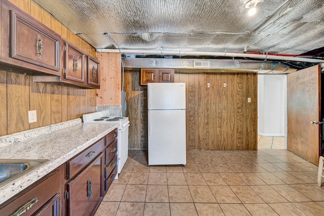 3716 Bower Rd, Roanoke, VA 24018 - kitchen with white appliances, wooden walls, light tile patterned flooring, light stone counters, and brown cabinets