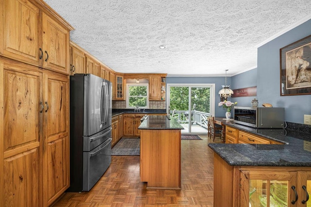 420 Cresthill Rd, Lynchburg, VA 24504 - kitchen featuring stainless steel appliances, ornamental molding, brown cabinets, a center island, and dark stone counters