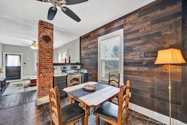 1521 Church Ave SE, Roanoke, VA 24013 - dining space featuring a ceiling fan, wood walls, and dark tile patterned floors