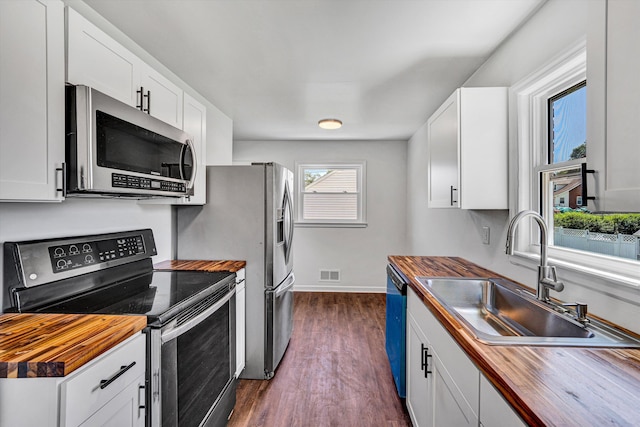 3113 Birchlawn Ave NW, Roanoke, VA 24012 - kitchen with appliances with stainless steel finishes, wood counters, dark wood-style flooring, and white cabinetry