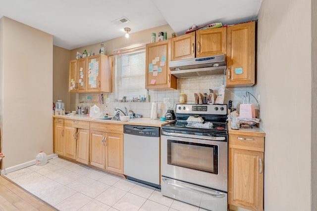 1406 Melrose Ave NW, Roanoke, VA 24017 - kitchen featuring stainless steel appliances, under cabinet range hood, decorative backsplash, light countertops, and glass insert cabinets
