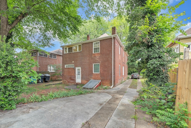 1406 Melrose Ave NW, Roanoke, VA 24017 - back of property featuring brick siding, a chimney, and driveway
