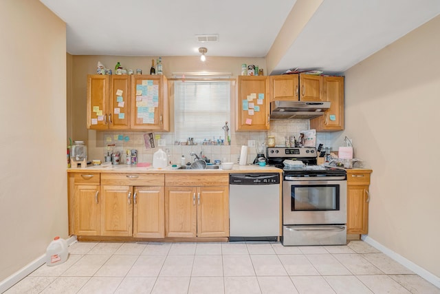1406 Melrose Ave NW, Roanoke, VA 24017 - kitchen with appliances with stainless steel finishes, under cabinet range hood, tasteful backsplash, light tile patterned floors, and light countertops