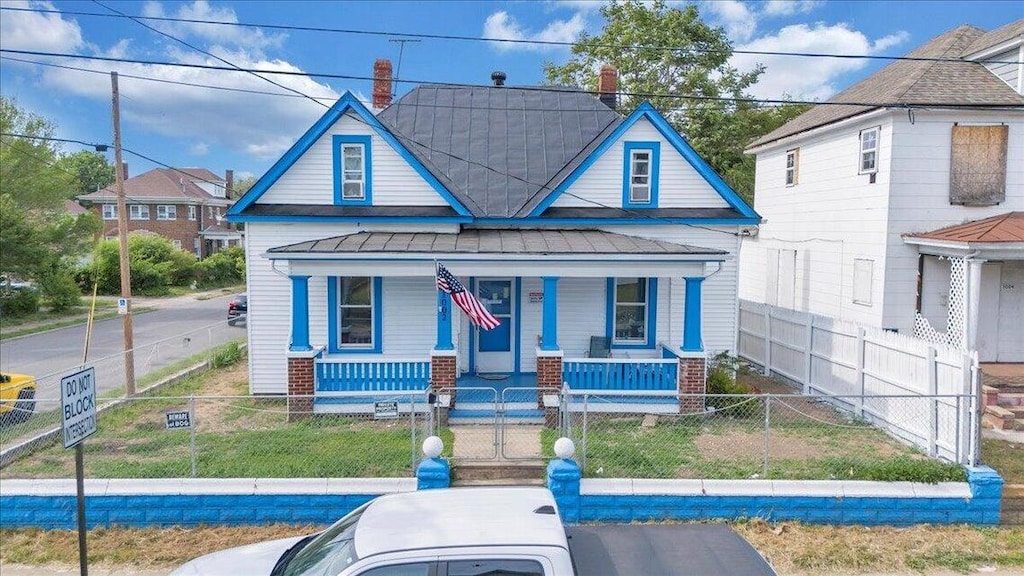 1002 Jamison Ave SE, Roanoke, VA 24013 - view of front of property with a porch, a standing seam roof, a fenced front yard, a metal roof, and a gate
