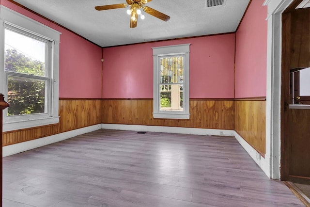 610 18th St SE, Roanoke, VA 24013 - empty room featuring plenty of natural light, a wainscoted wall, ceiling fan, wood finished floors, and wood walls
