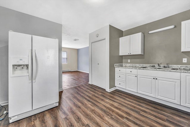 112 Harrison Ave NW, Roanoke, VA 24016 - kitchen with white fridge with ice dispenser, dark wood-style floors, white cabinets, light stone countertops, and a baseboard heating unit