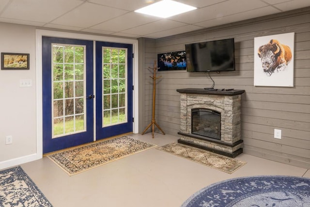 115 Armistead Ln, Rustburg, VA 24588 - entryway with french doors, a paneled ceiling, a fireplace, wood walls, and concrete flooring