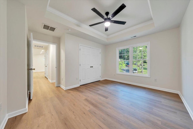 2315 Vale Ave, Roanoke, VA 24012 - unfurnished bedroom featuring a tray ceiling, ornamental molding, light wood-type flooring, ceiling fan, and a closet