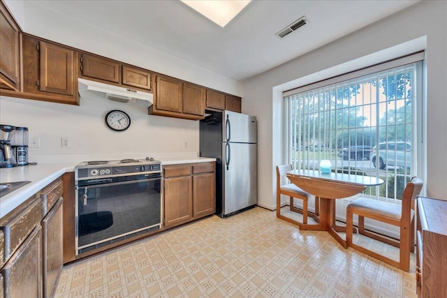 850 Stonegate Ct, Salem, VA 24153 - kitchen with electric range oven, freestanding refrigerator, under cabinet range hood, light countertops, and light flooring