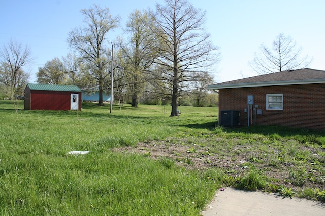 view of yard with central AC and an outdoor structure