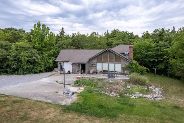 view of front facade with a front lawn and a patio area