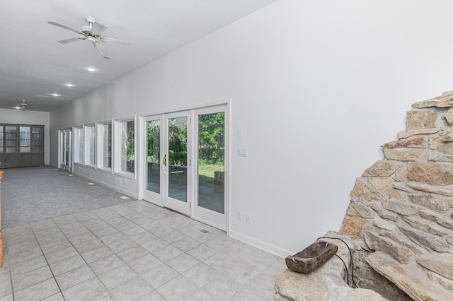 carpeted spare room featuring high vaulted ceiling, ceiling fan, and french doors