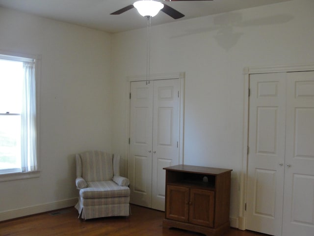 living area with ceiling fan and dark hardwood / wood-style floors