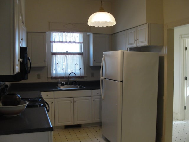 kitchen with white cabinetry, white refrigerator, light tile floors, and sink