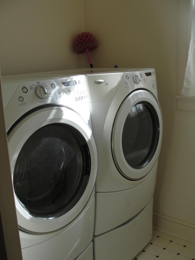 laundry room with separate washer and dryer and light tile floors