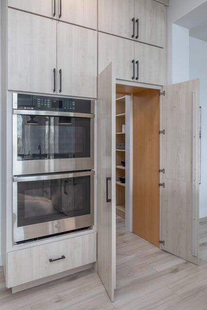 interior space with stainless steel double oven and light hardwood / wood-style floors