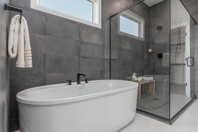 bathroom featuring tile walls, tile floors, and separate shower and tub