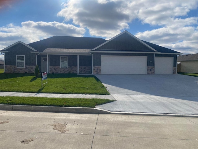 ranch-style home featuring a front yard, stone siding, and concrete driveway