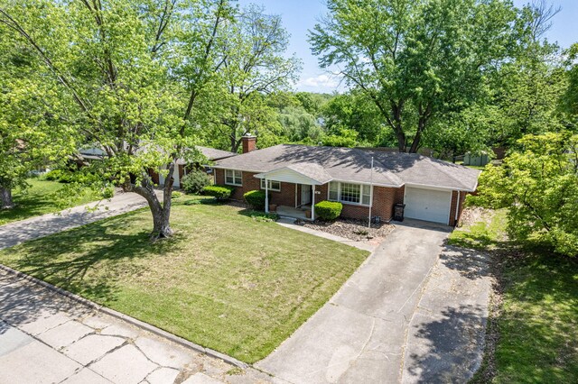 ranch-style house featuring brick siding, a garage, driveway, a front yard, and a chimney
