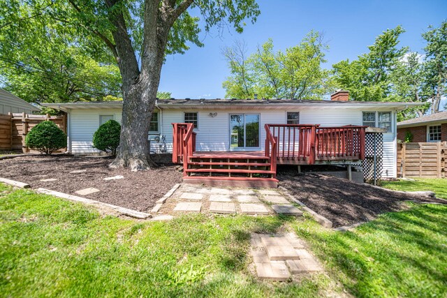back of house featuring a wooden deck and a chimney