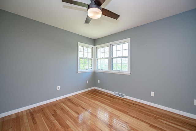 unfurnished room featuring baseboards, light wood-style floors, and a ceiling fan