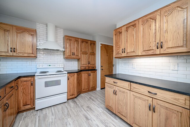kitchen featuring white range with electric stovetop, wall chimney exhaust hood, dark countertops, and tasteful backsplash
