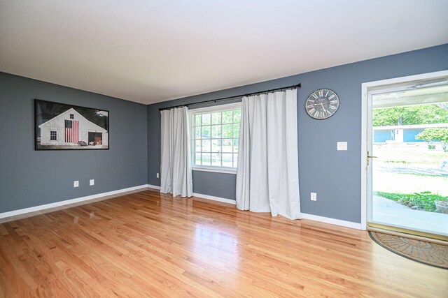 unfurnished living room with light wood-style flooring and baseboards