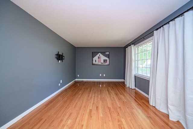 unfurnished room featuring light wood finished floors and baseboards