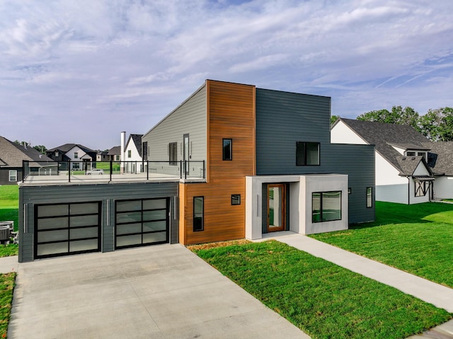 contemporary house featuring a residential view, concrete driveway, a balcony, and a front lawn