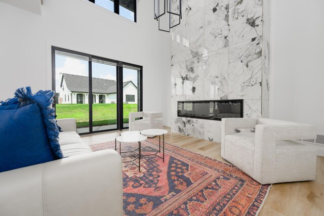 living room featuring a tiled fireplace, light wood-type flooring, and tile walls