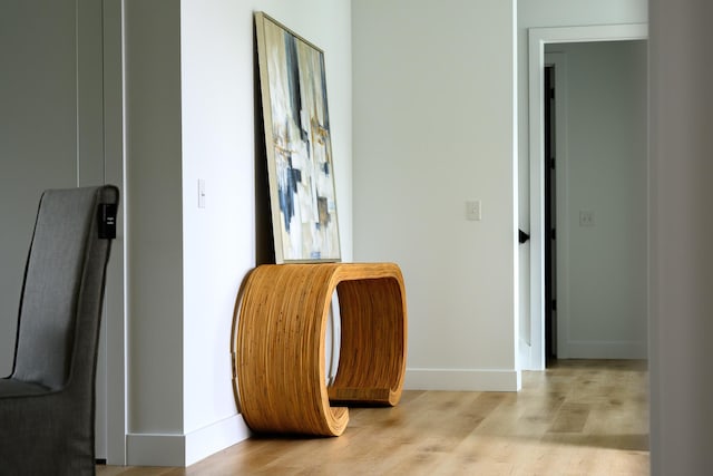 corridor featuring light wood finished floors and baseboards