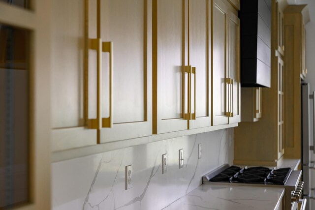 interior space with decorative backsplash, stove, and wall chimney range hood