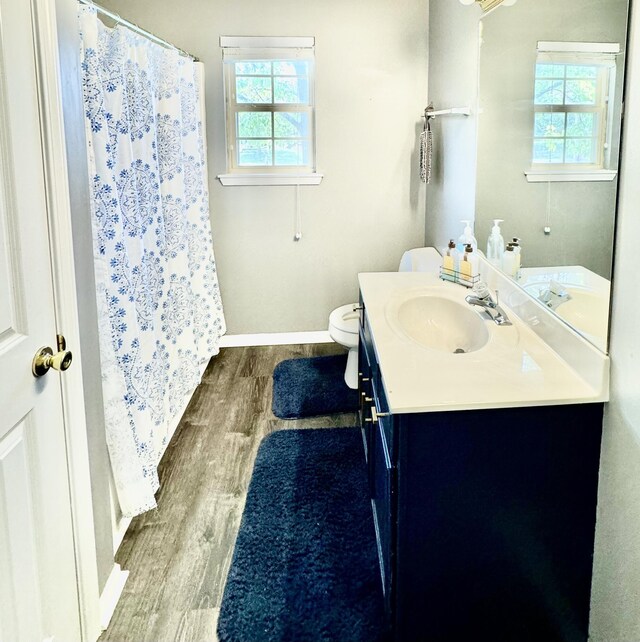 bathroom featuring vanity, hardwood / wood-style floors, a wealth of natural light, and toilet