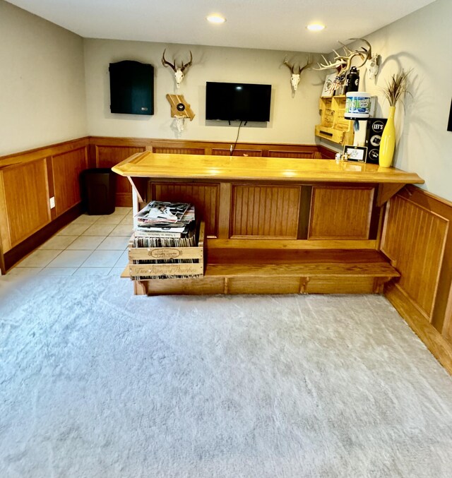 bar with light tile patterned floors and wooden counters