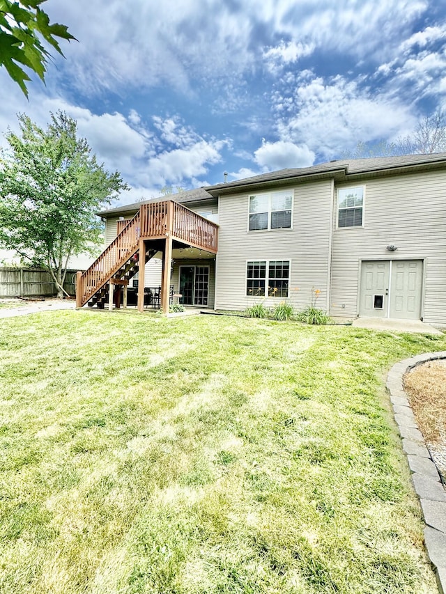 back of property with a deck and a lawn