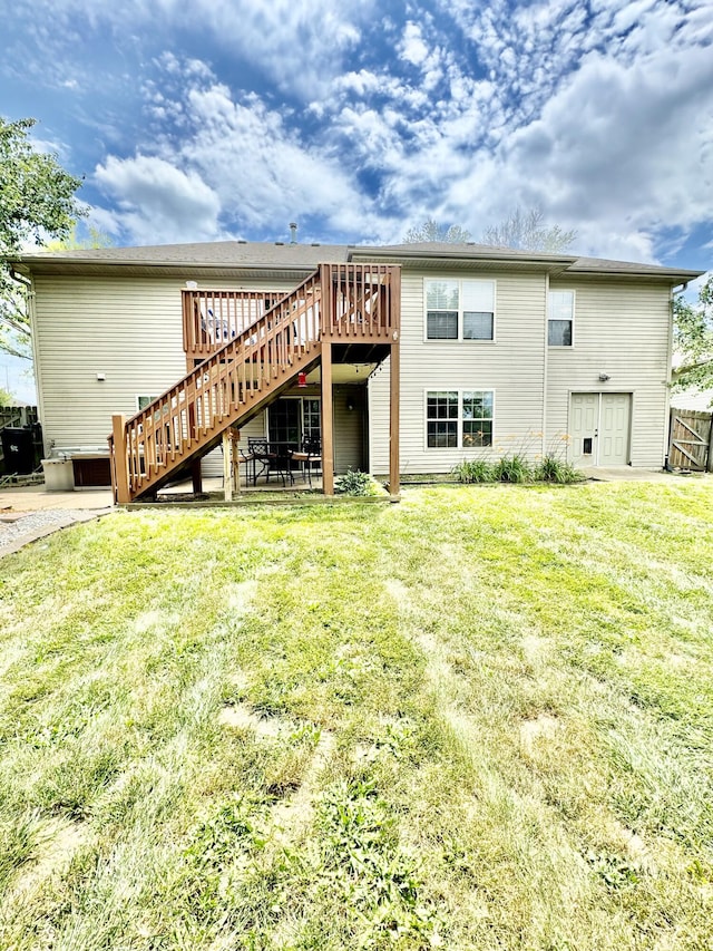 rear view of house with a wooden deck and a lawn