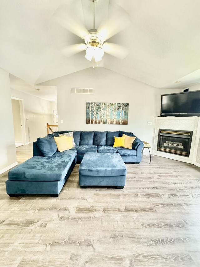 living room featuring hardwood / wood-style flooring, lofted ceiling, and ceiling fan