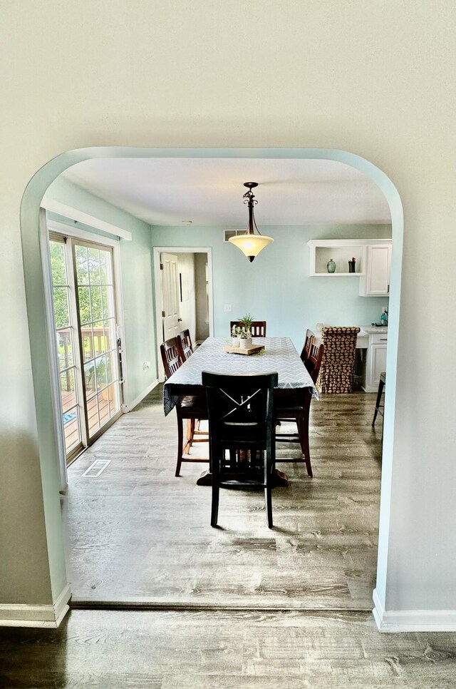 dining space with wood-type flooring