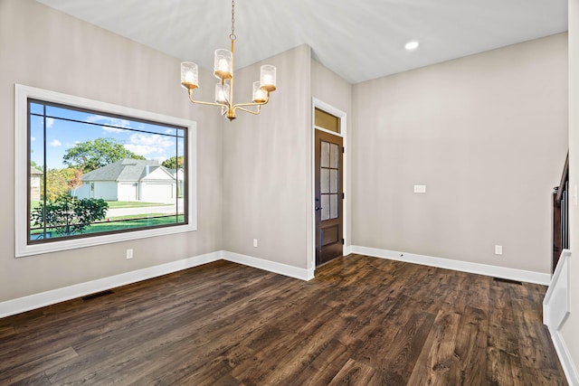 empty room with a notable chandelier and dark hardwood / wood-style flooring