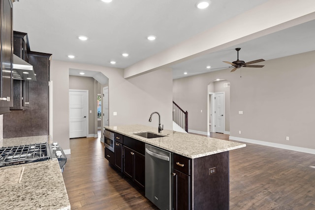 kitchen featuring ceiling fan, dark wood-type flooring, a kitchen island with sink, sink, and dishwasher