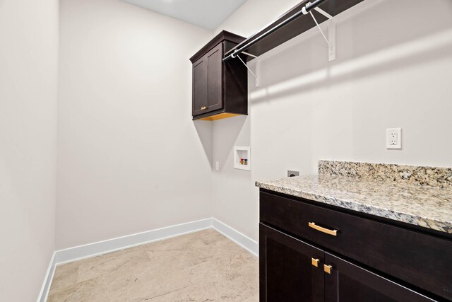 washroom with cabinets, washer hookup, and light tile floors