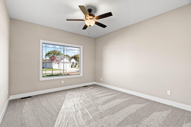 empty room featuring ceiling fan and light colored carpet