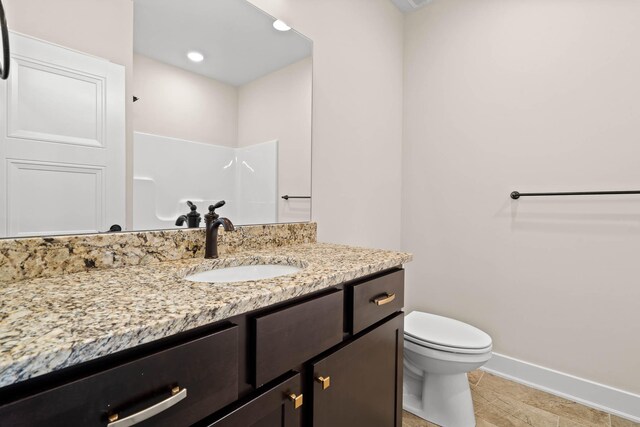 bathroom with toilet and vanity with extensive cabinet space